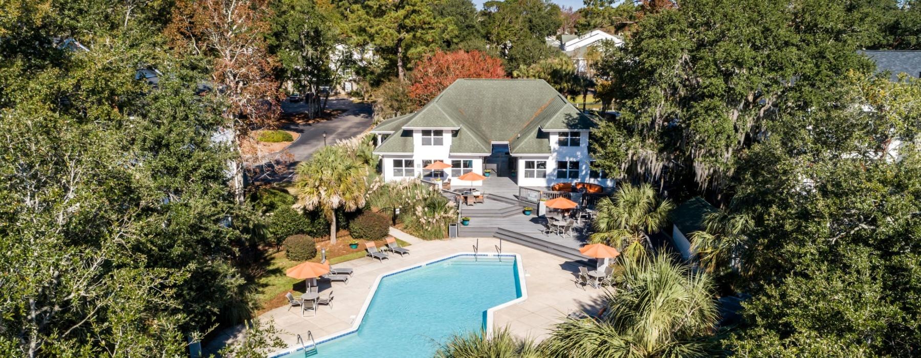 a pool surrounded by trees and houses